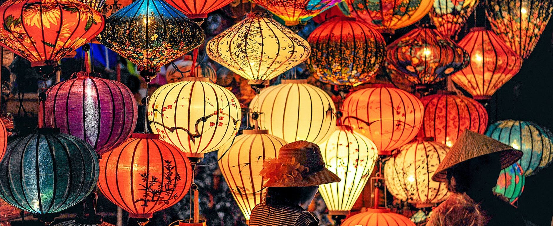 two person standing near assorted color paper lanterns